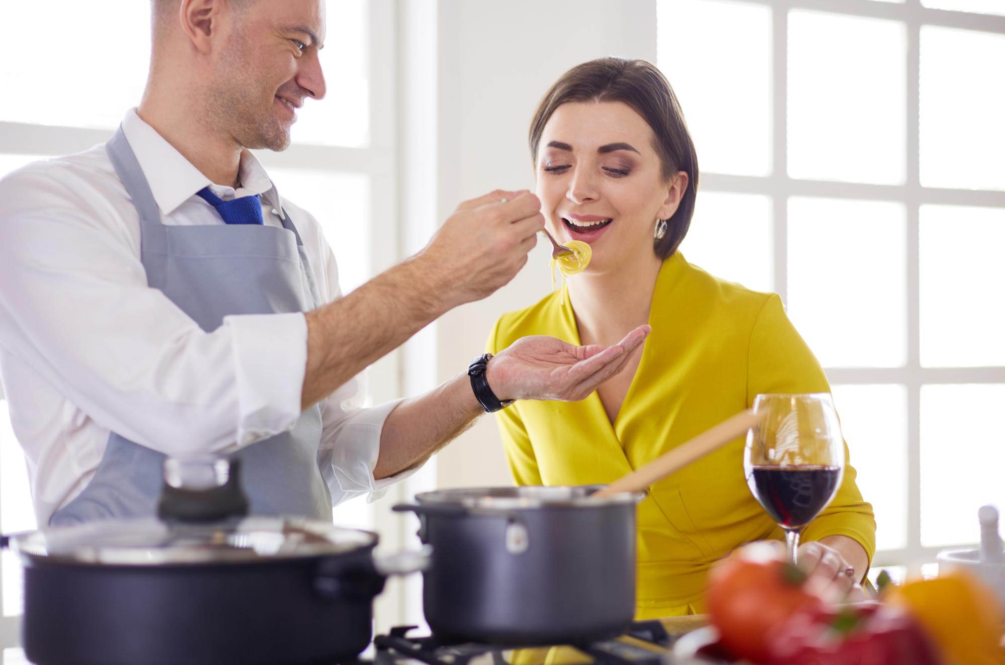 Two cooks tasting a stew in studio